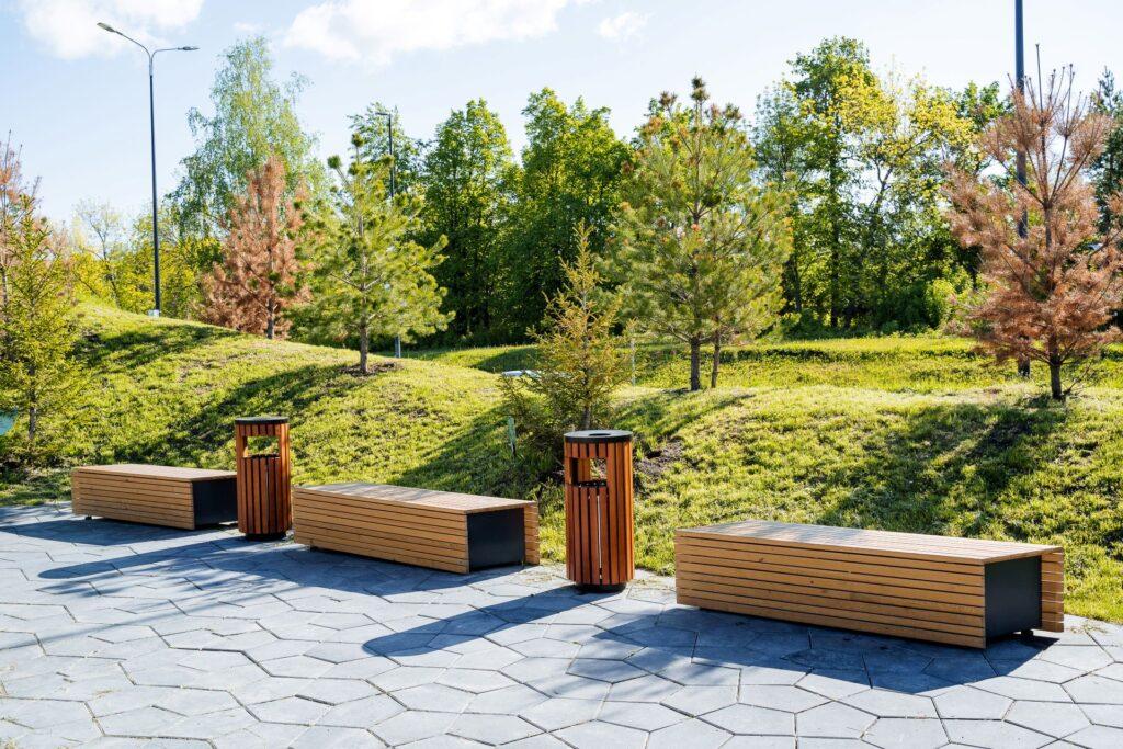 Schöne Landschaftsgestaltung des Stadtparks, ein angenehmer Ort für Spaziergänge und Erholung der Bürger, Holzbänke zum Sitzen, ein Gehweg im Park. 